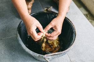 Main photo for Fast Fashion Vs Slow Fashion. Hands soaking sustainable cotton before spinning process