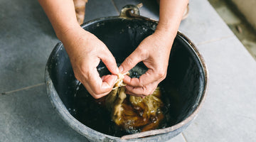 Main photo for Fast Fashion Vs Slow Fashion. Hands soaking sustainable cotton before spinning process