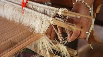 Hand weaving cotton on traditional wooden loom