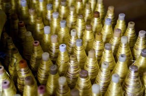 Yellow silk bobbins with Ikat tie dye ready for handloom weaving